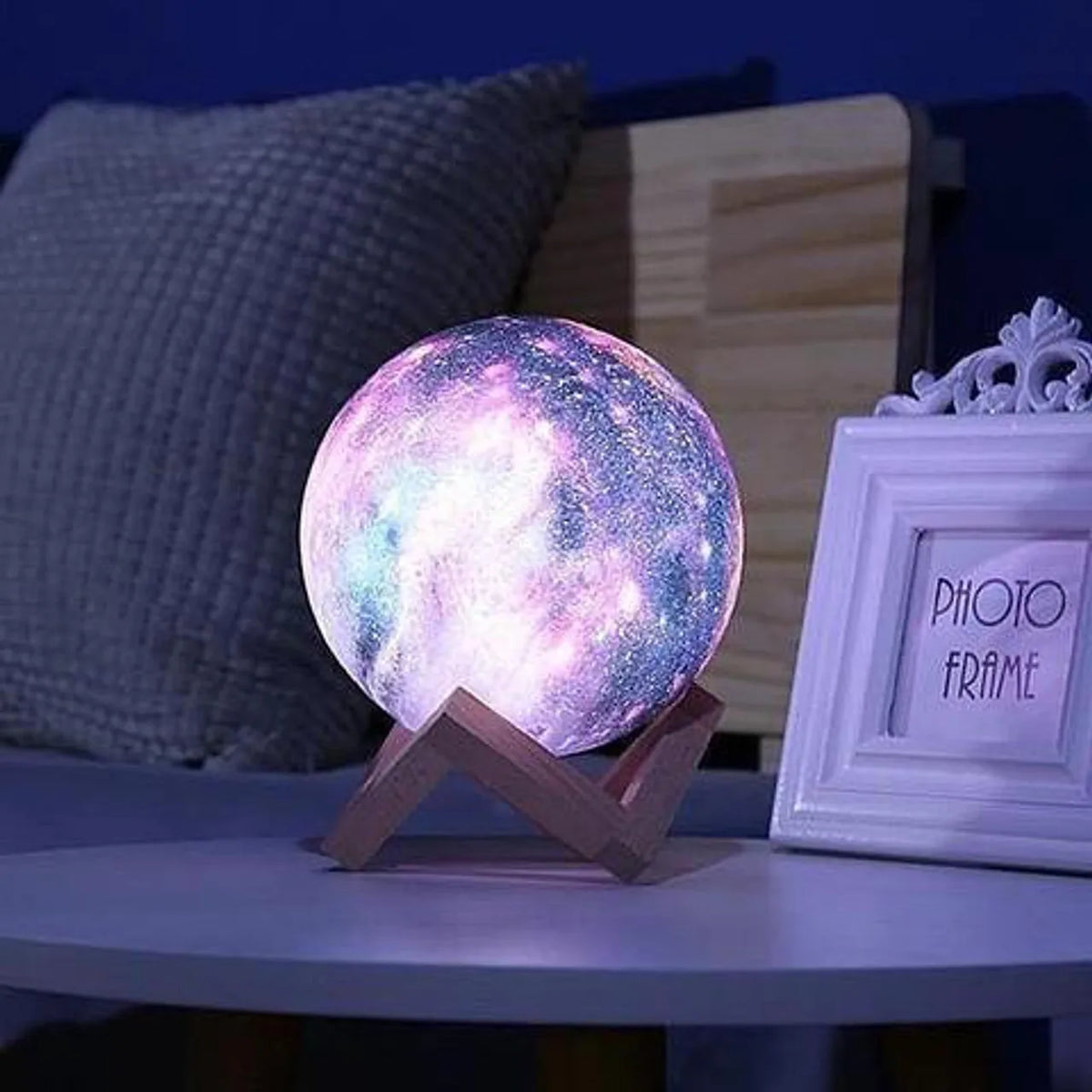 galaxy moon lamp with 3D printed lunar surface glowing on a nightstand in a dark bedroom